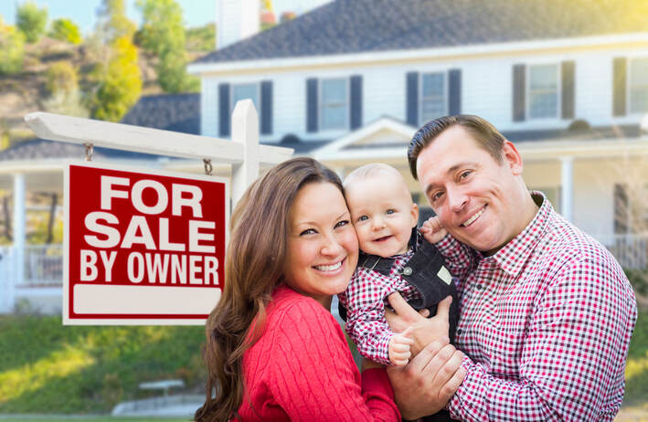 Family standing in front of home with for sale by owner sign